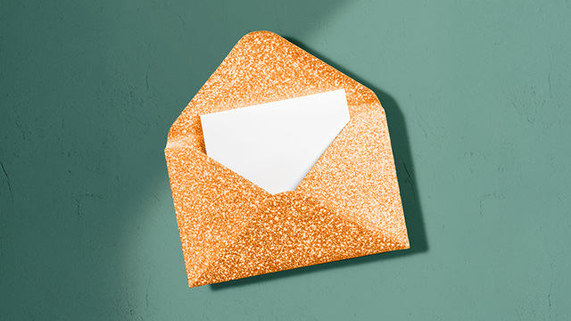 Glittery orange envelope on a green background